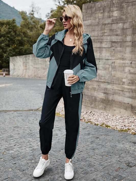 Conjunto cazadora con cremallera con capucha de color combinado con pantalones deportivos